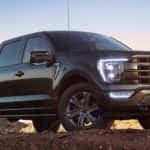 A black 2022 Ford F-150 XL Sport parked off-road on a ridge.