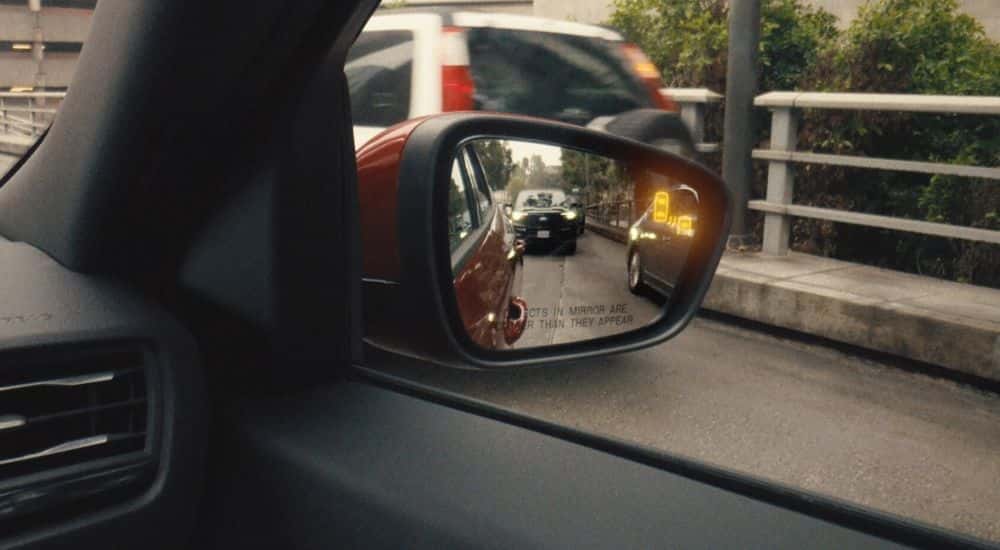 Close-up of the illuminated Blind Spot Alert icon on the side mirror of a 2025 Ford Escape for sale.