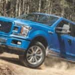 A blue 2018 Ford F-150 for sale near Lawrenceville is shown off-roading.