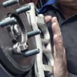 A Ford mechanic near you is shown working on a caliper.