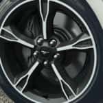 A close up show the front passenger tire on a silver 2023 Ford Mustang at a tire shop.