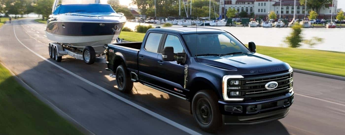 A black 2025 Ford F-350 Platinum towing a small boat.