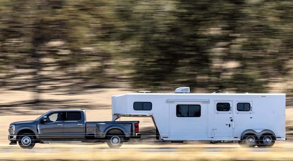 A grey 2025 Ford F-350 towing a trailer.