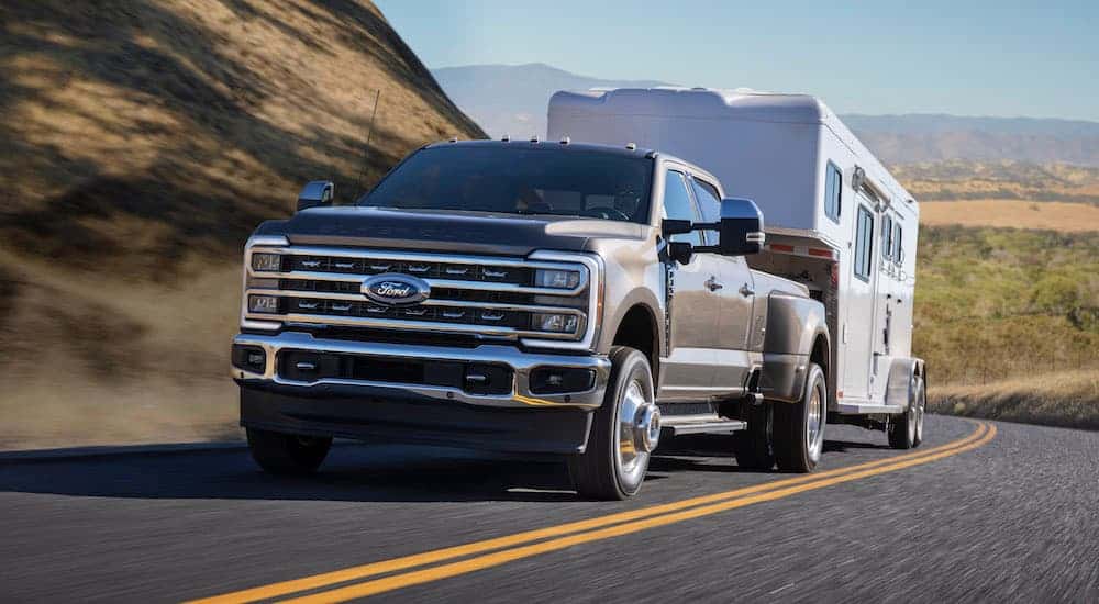 A grey 2025 Ford F-350 towing a trailer.