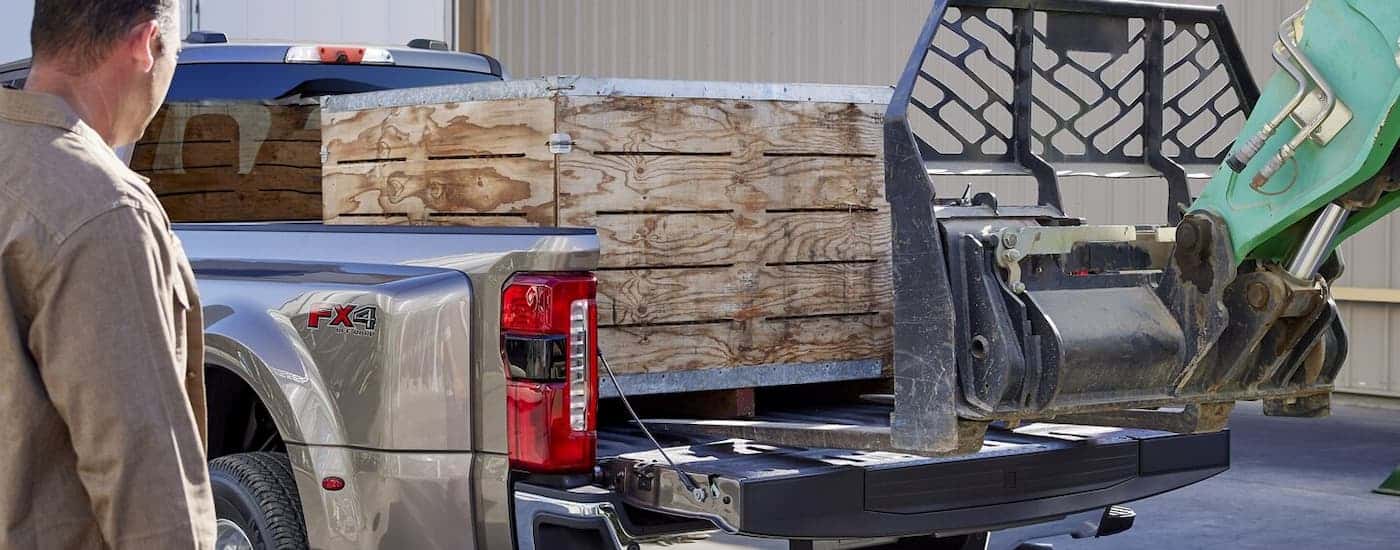 A grey 2025 Ford F-350 being loaded with a pallet by a forklift.