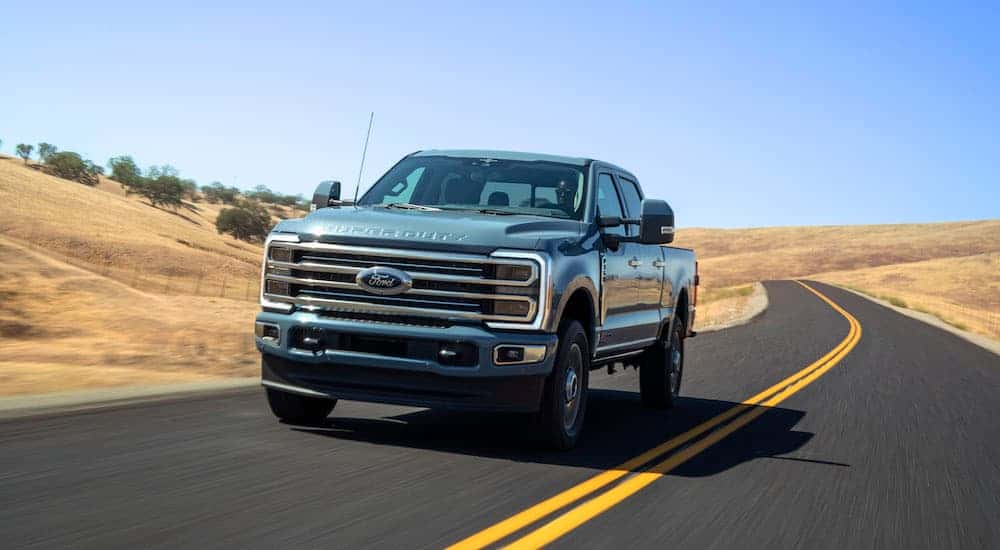 A green 2025 Ford F-350 on a rural road.