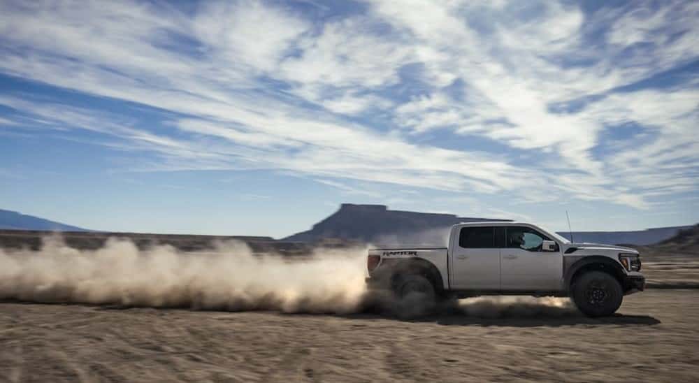 A white 2025 Ford F-150 Raptor off-roading.