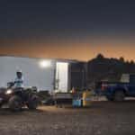 A blue 2025 Ford F-150 Tremor towing a trailer off-road.