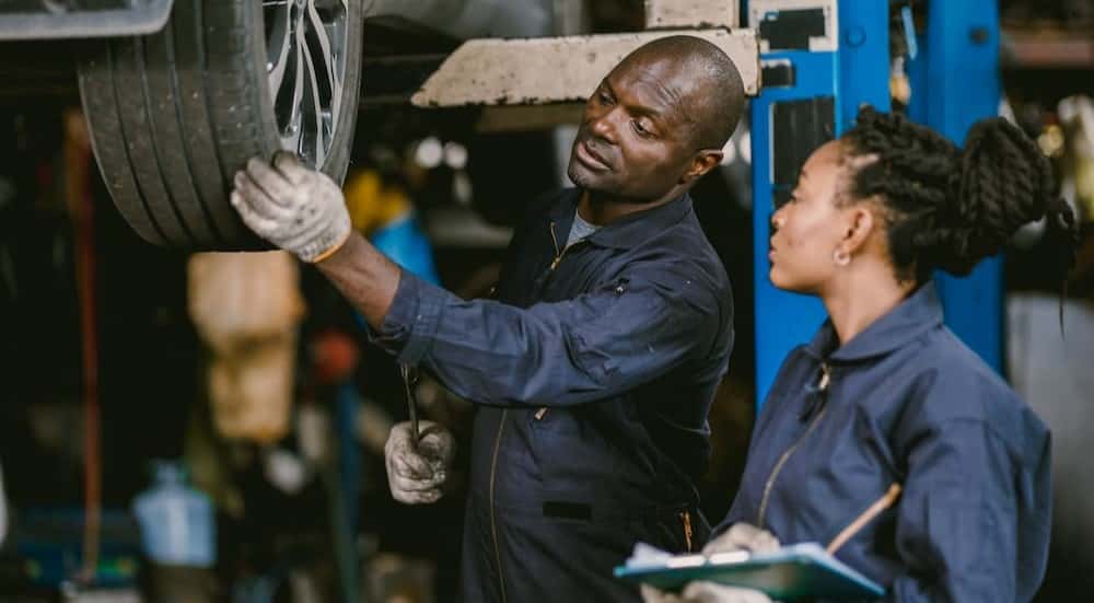 Two technicians evaluating a tire at a tire shop near Conyers.
