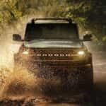 A 2025 Ford Bronco off-roading in mud