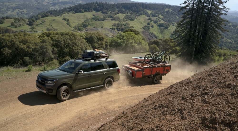 A green 2024 Ford Expedition Timberline driving on a trail.