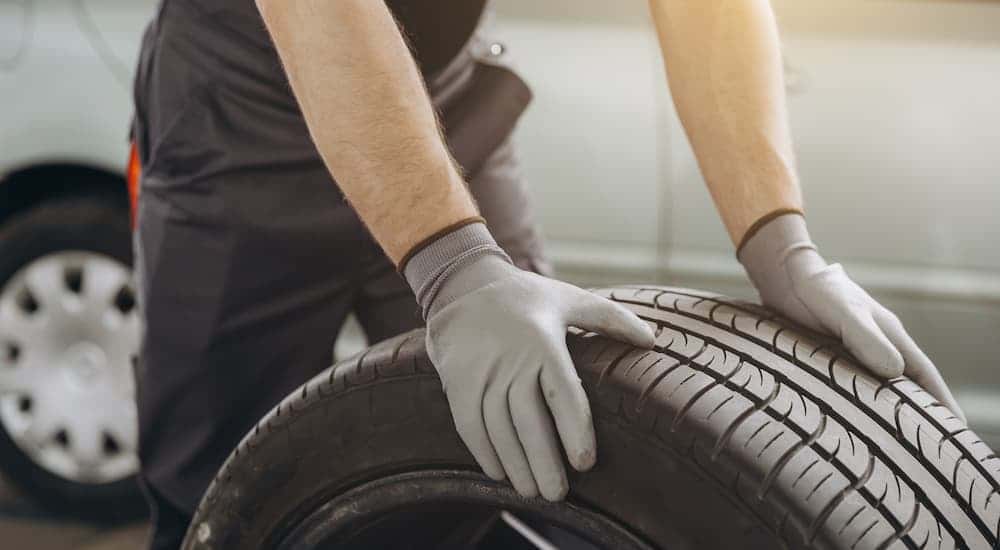 A technician rolling a tire in a tire shop