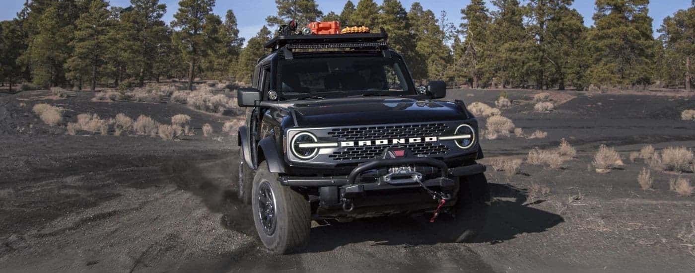 A black 2024 Ford Bronco off-roading on gravel