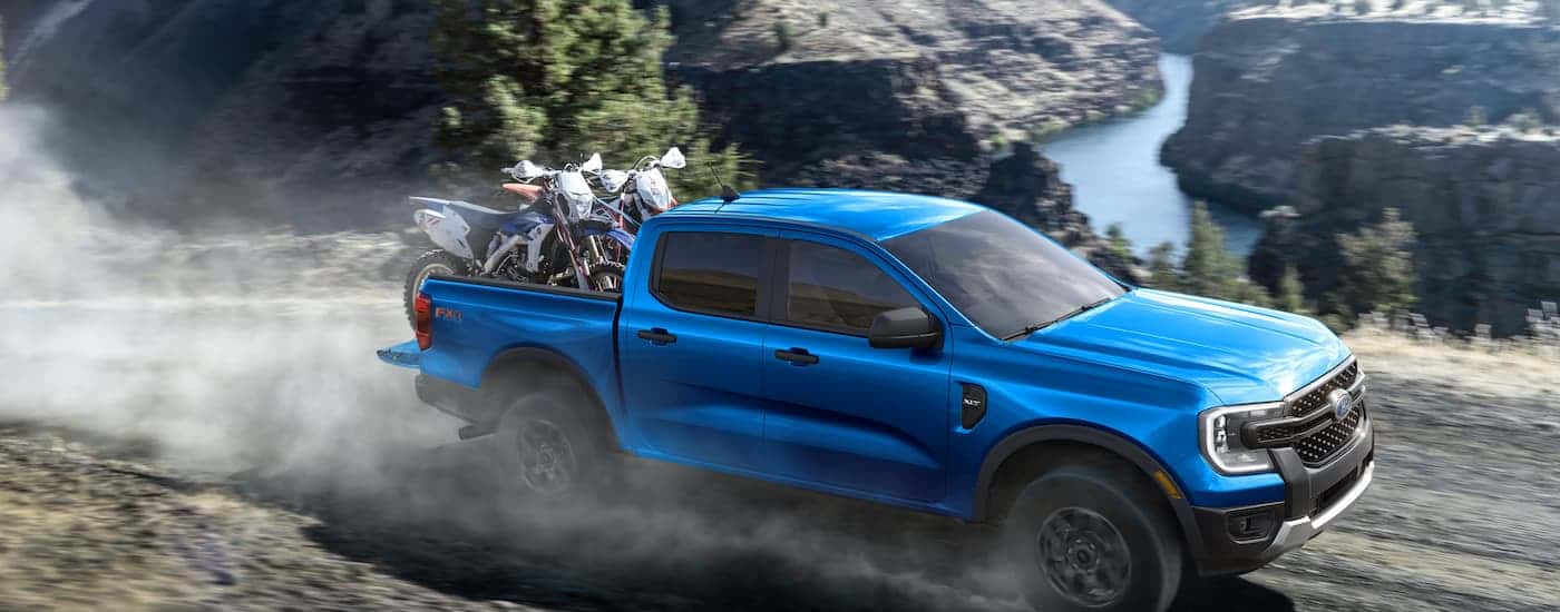 A blue 2025 Ford Ranger off-roading on a dirt road