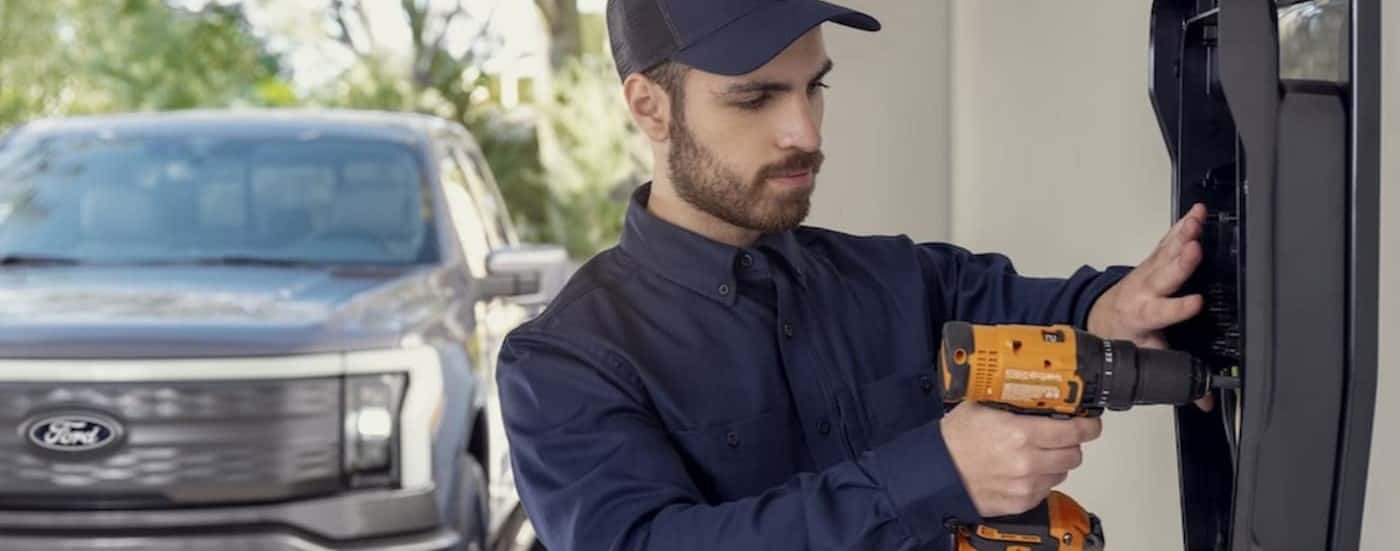 A technician installing a charge station in a garage.