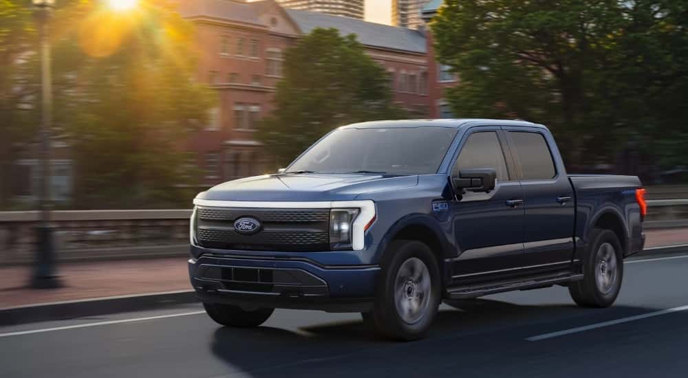 A blue 2025 ford F-150 Lightning from the front at an angle.