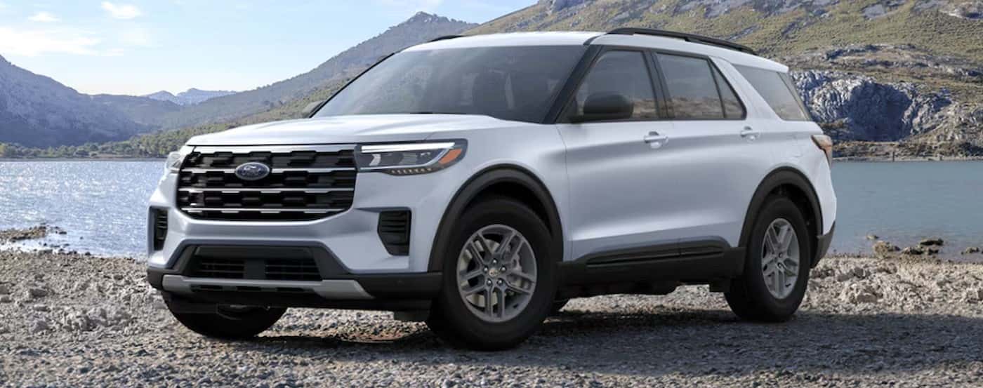 A white 2025 Ford Explorer ACTIVE parked near a lake.