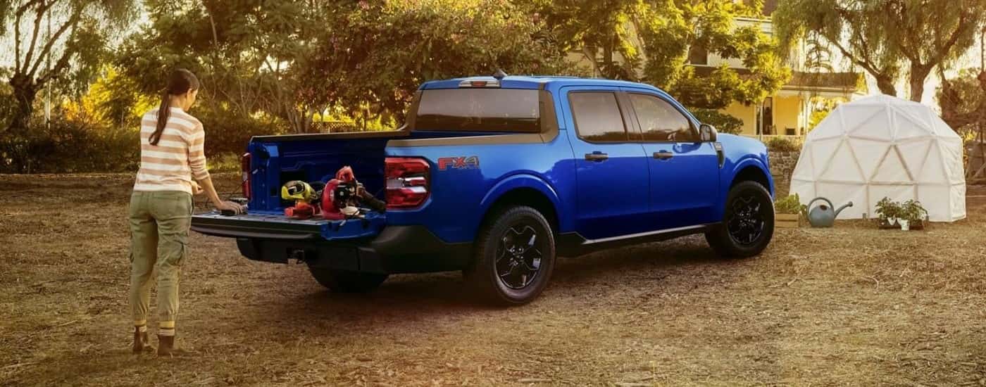 Person working out of the tailgate of a blue 2025 Ford Maverick XLT.