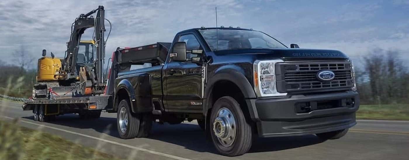 A black 2025 Ford F-450 towing a trailer.