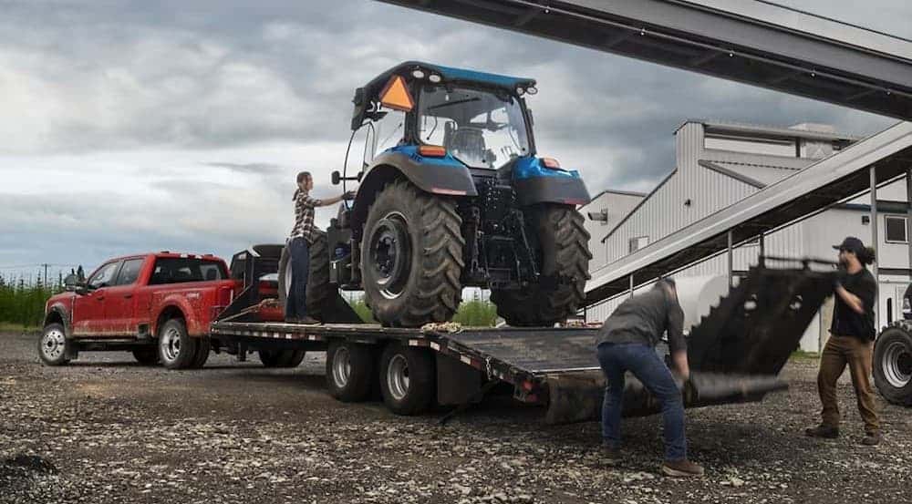 A red 2025 Ford F-450 towing a trailer.