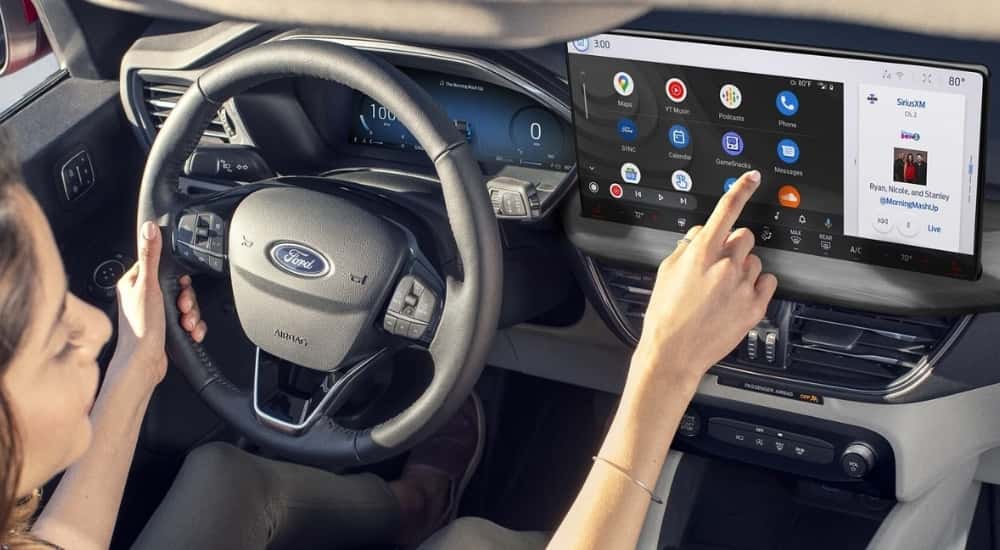 Person checking messages in a 2025 Ford Escape for sale near Monroe