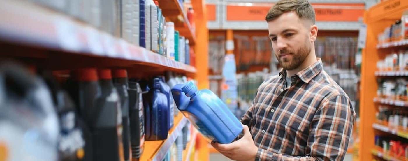 A person looking at an oil container.