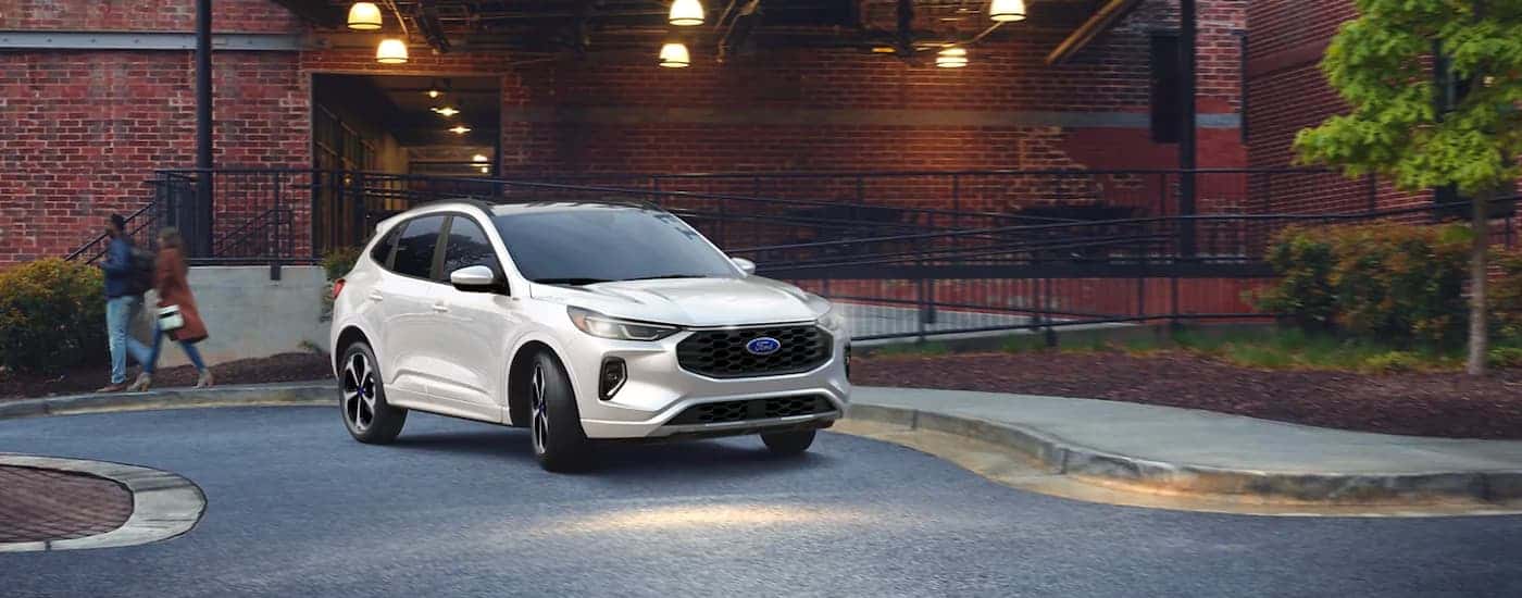 A white 2024 Ford Escape ST parked outside a building