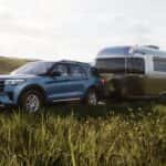 A blue 2025 Ford Explorer Active for sale in Loganville towing a trailer.