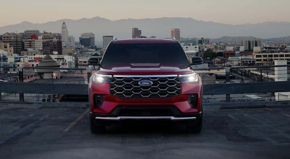 A red 2025 Ford Explorer Platinum parked in a city.