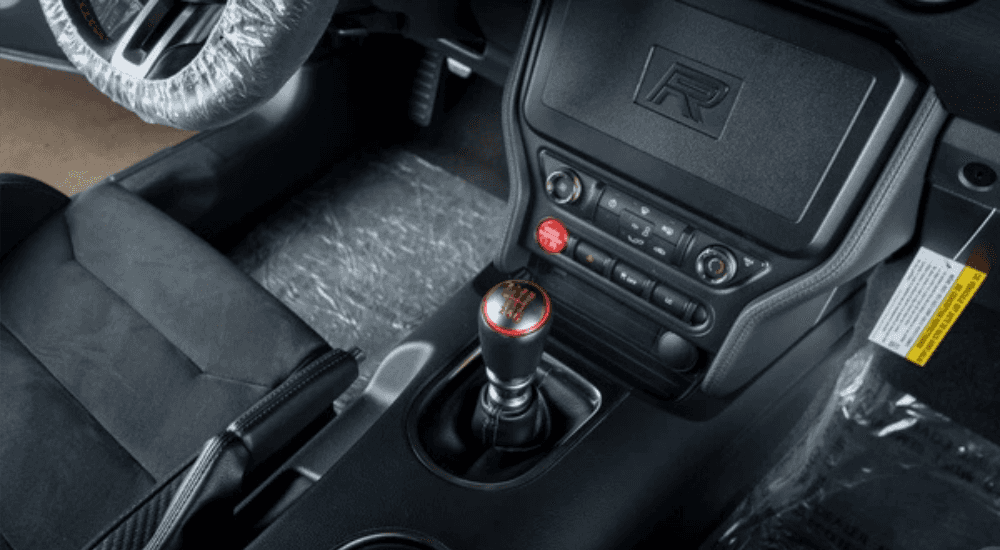 The manual gear shift in a black leather interior.