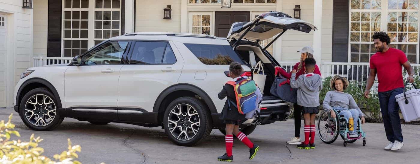 A family is near a white 2025 Ford Explorer for sale near Walnut Grove.