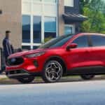 A red 2026 Ford Escape parked near two people.
