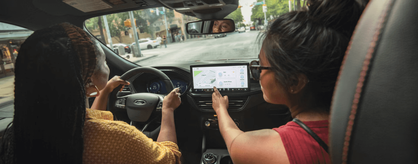 Two friends interacting with the infotainment system in a 2026 Ford Escape
