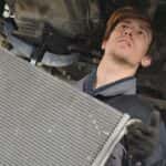 Technician performing car radiator repair near Lawrenceville