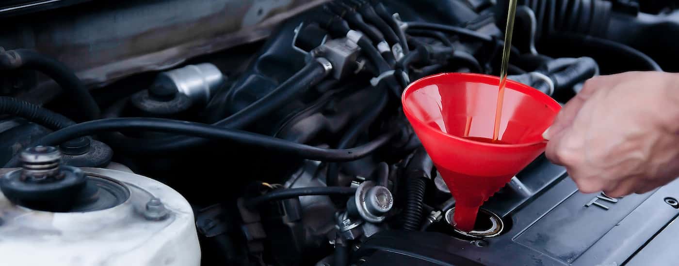 A person adding oil to their engine