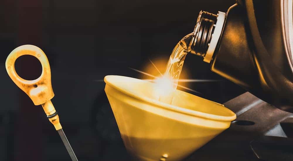 Oil can being poured into a funnel during an oil change near monroe.