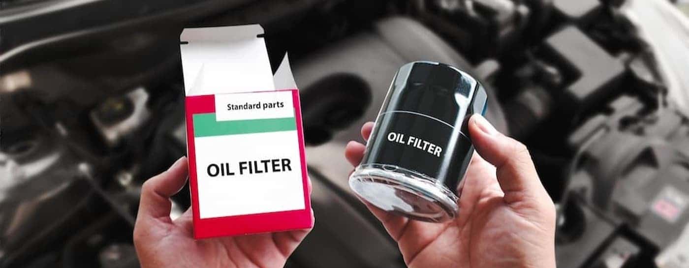 A person holding an oil filter.