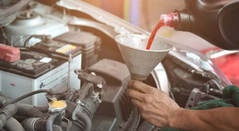 Transmission fluid being poured into a funnel.