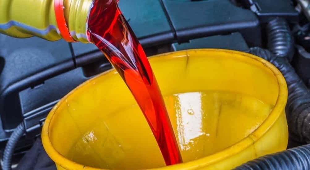 Transmission fluid being poured into a funnel.