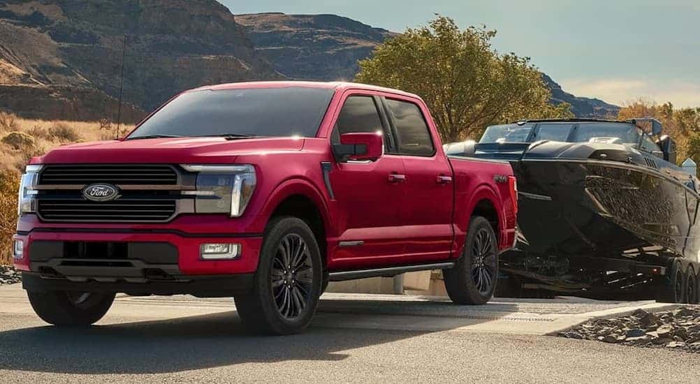 A red 2026 Ford F-150 towing a boat.