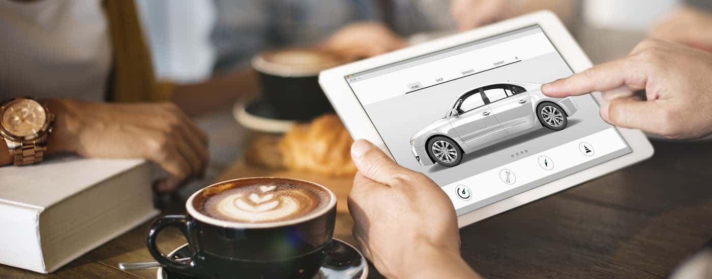 A person leasing a car on a tablet.