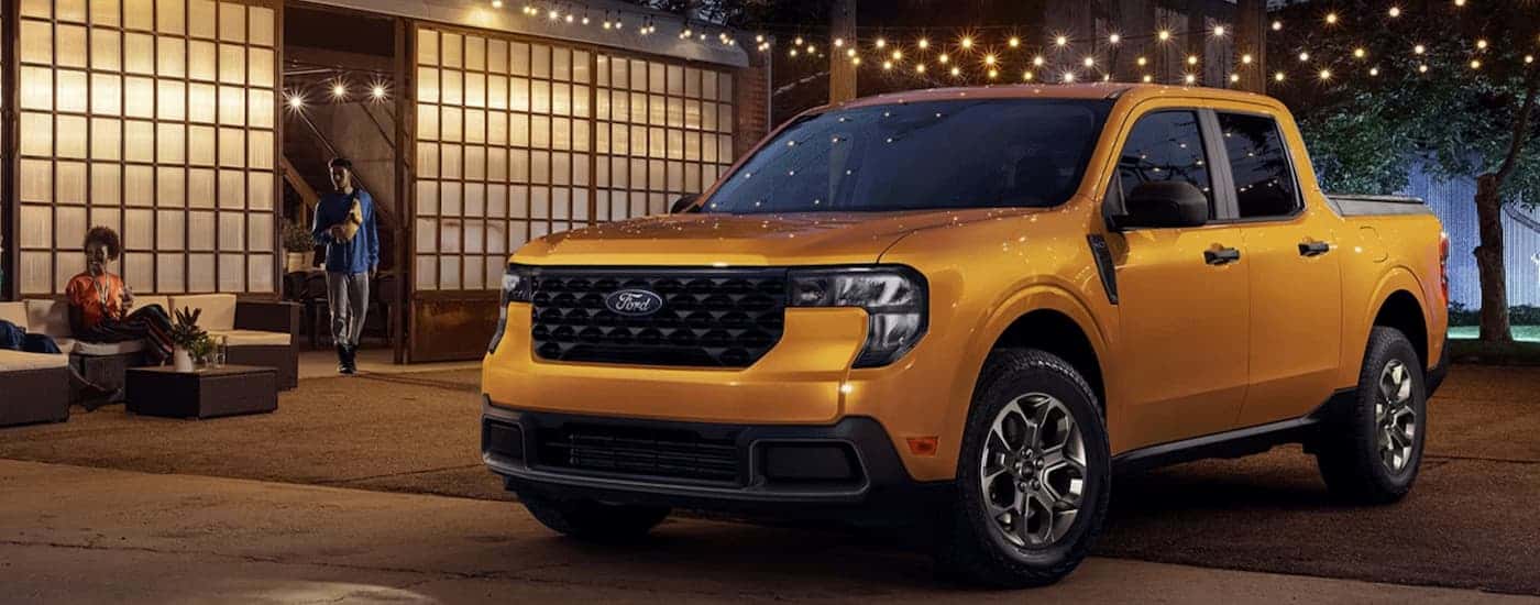 A yellow 2026 Ford Maverick parked outside a building