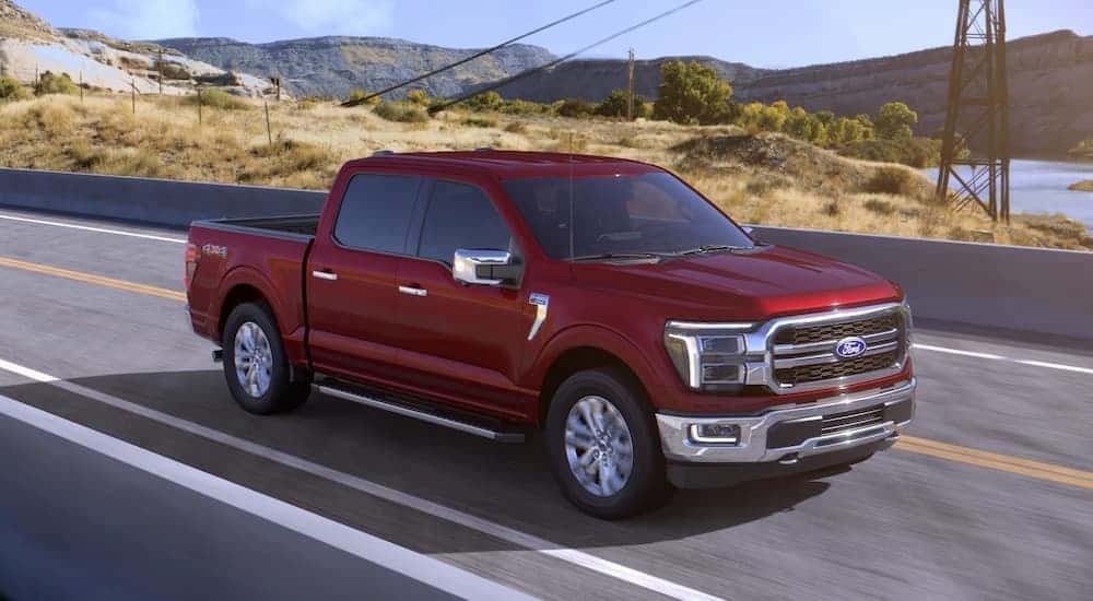 A red 2026 Ford F-150 driving down a highway