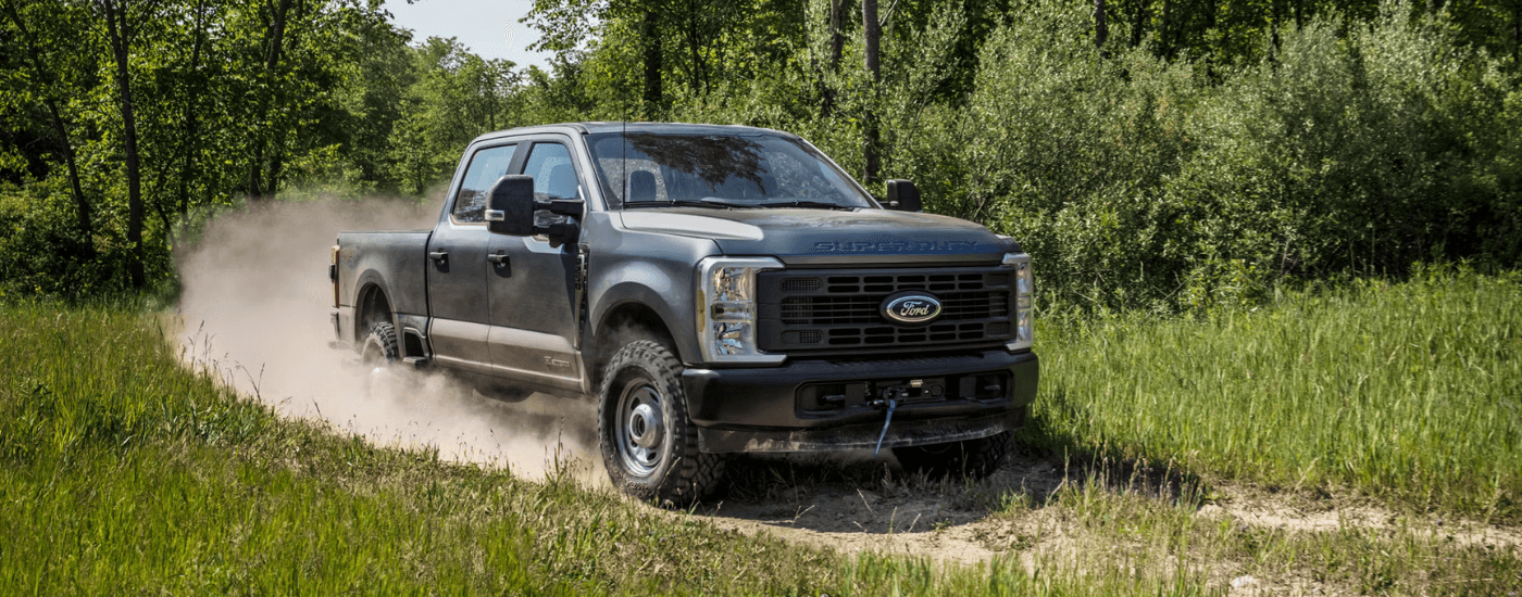 Blue 2026 Ford F-250 Super Duty driving down a trail