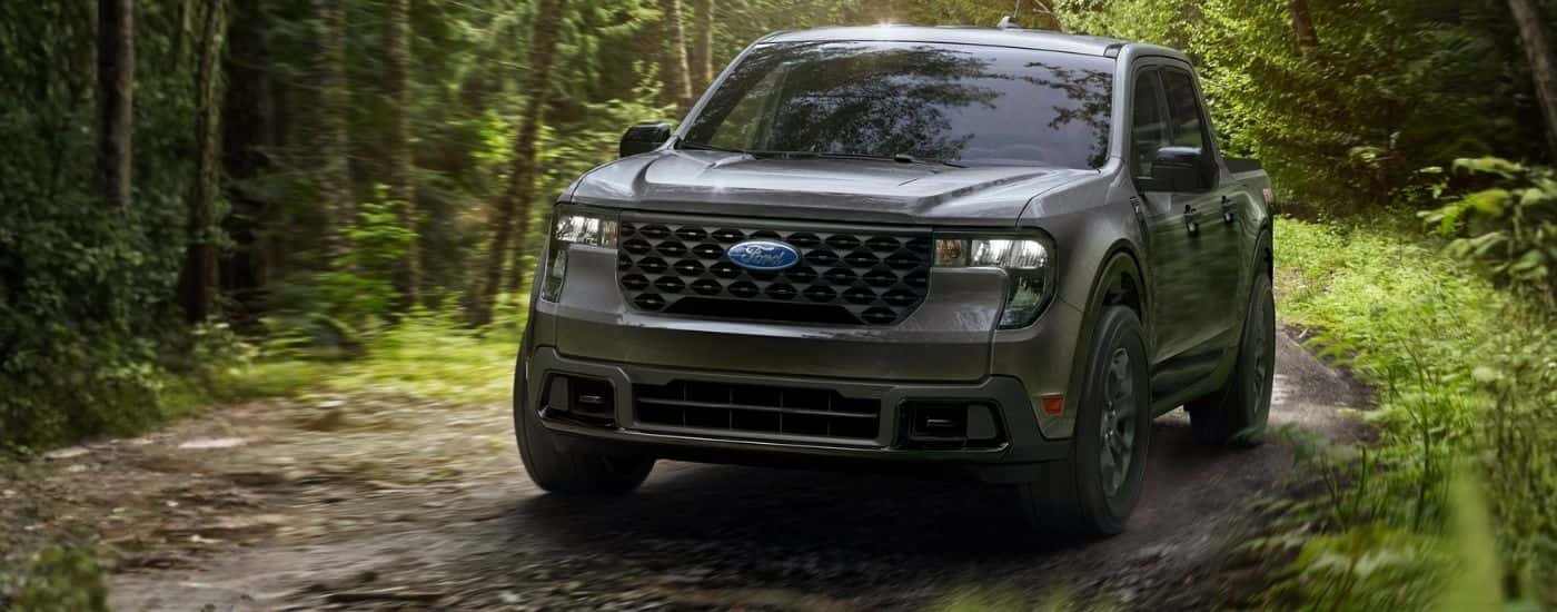 Grey 2026 Ford Maverick driving on a dirt road