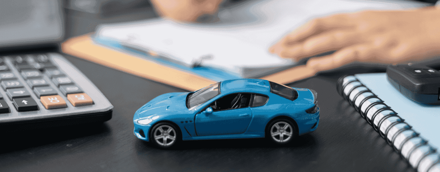 Blue toy car on a desk with paperwork