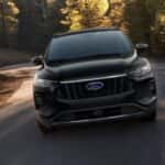A black 2024 Ford Escape driving down a road
