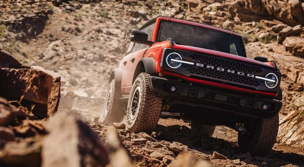 A red 2026 Ford Bronco off-roading on rocks