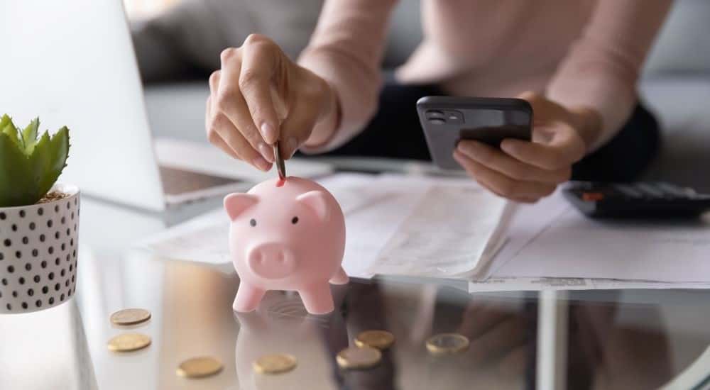 Piggy bank shown while a person calculates their budget