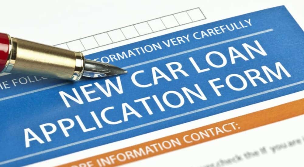 New car loan application page with pen